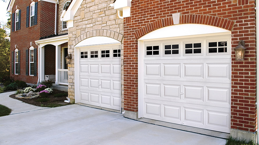 Brick And Stone House with White Garage Doors